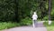 Grandma walks in the park with sticks for Nordic walking in retirement