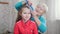 Grandmother brushing her granddaughters hair. The girl in red shirt