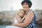 Grandmother and child, cute blond boy and young granny, hugging on the beach