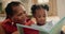 Grandmother, child and reading a book for storytelling, home and fiction in living room. Black family, love and bonding