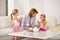 Grandmother, children and talking with tea cup in living room for bonding, playing and breakfast or brunch at home