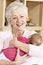 Grandmother Cuddling Granddaughter At Home