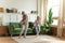 Grandmother dancing with little girl granddaughter in cozy apartment
