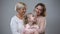 Grandmother, daughter and grandchild hugging on grey background, trust relations