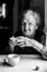 Grandmother drinking tea. Black-and-white portrait of woman.