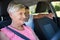 Grandmother driving a car while grandson sitting in the back seat