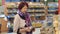 Grandmother of eighty years picks and buys bread at the grocery store.