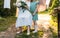 Grandmother, elderly woman sitting and hugging her granddaughter, girl and holding a bouquet of flowers in the garden