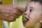 Grandmother feeding her little baby granddaughter at home