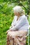 The grandmother in garden under a blossoming