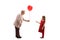 Grandmother giving a red balloon to a girl in a red dress