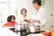 Grandmother And Grandchildren Cooking Meal At Home