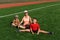 Grandmother and grandchildren sit on the grass