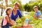 Grandmother With Grandchildren Working On Allotment