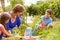 Grandmother With Grandchildren Working On Allotment