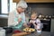 Grandmother and granddaughter adding blue berries to the crust