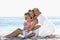 Grandmother With Granddaughter And Daughter Relaxing On Beach