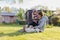 Grandmother with granddaughter and dog playing on the sunbathing lawn