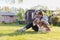 Grandmother with granddaughter and dog playing on the sunbathing lawn