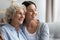 Grandmother and granddaughter with healthy smile hugging close up