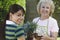 Grandmother And Granddaughter Holding Potted Plants