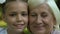 Grandmother and granddaughter looking in camera, generation, faces closeup