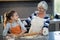 Grandmother and granddaughter looking at each other while flattening dough