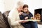 Grandmother And Granddaughter Reading Book At Home Together