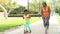 Grandmother And Granddaughter Riding Scooters In Park