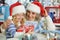 Grandmother and granddaughter in Santa hats making New Year& x27;s decorations