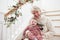 Grandmother With Granddaughter Sits On Stairs At Christmas