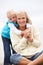 Grandmother And Granddaughter Sitting On Beach