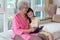 Grandmother and granddaughter sitting on sofa and reading book h