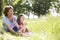 Grandmother And Granddaughter Sitting In Summer Field