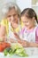 Grandmother and granddaughter stirring salad