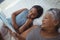 Grandmother and granddaughter watching photo album together in bed room