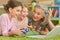 Grandmother and granddaughters playing on laptop