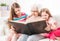 Grandmother with granddaughters reading book