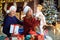 Grandmother and grandfather and girl are smiling in the house at Christmas.