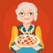 Grandmother grandma in a orange dress and glasses with cooked, fresh baked pie