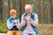 Grandmother with grandson drinking tea in forest