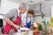 Grandmother with grandson in the kitchen preparing roast meat.