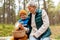 grandmother and grandson with mushrooms in forest