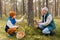 grandmother and grandson with mushrooms in forest