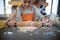 Grandmother helping granddaughter to flatten dough