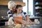 Grandmother helping granddaughter to flatten dough