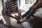 Grandmother helping granddaughter to wear shoes in bed room