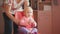 Grandmother with her cute granddaughter, landing on a chair, playing and combing