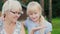 Grandmother with her granddaughter looking at a small snail in her hand. Concept - nature and life around, active