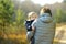 Grandmother with her toddler grandson having fun outdoors on beautiful autumn day. Grandma taking a walk with her grandchild